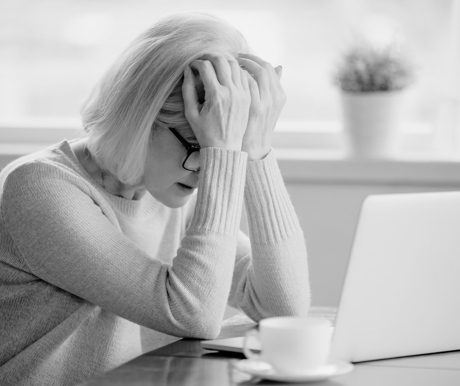Overwhelmed midlife woman experiencing brain fog and anxiety at work